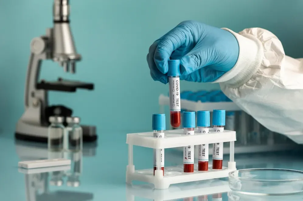 Kórházi laboratóriumi vizsgálat: vérminták elemzése mikroszkóp mellett.